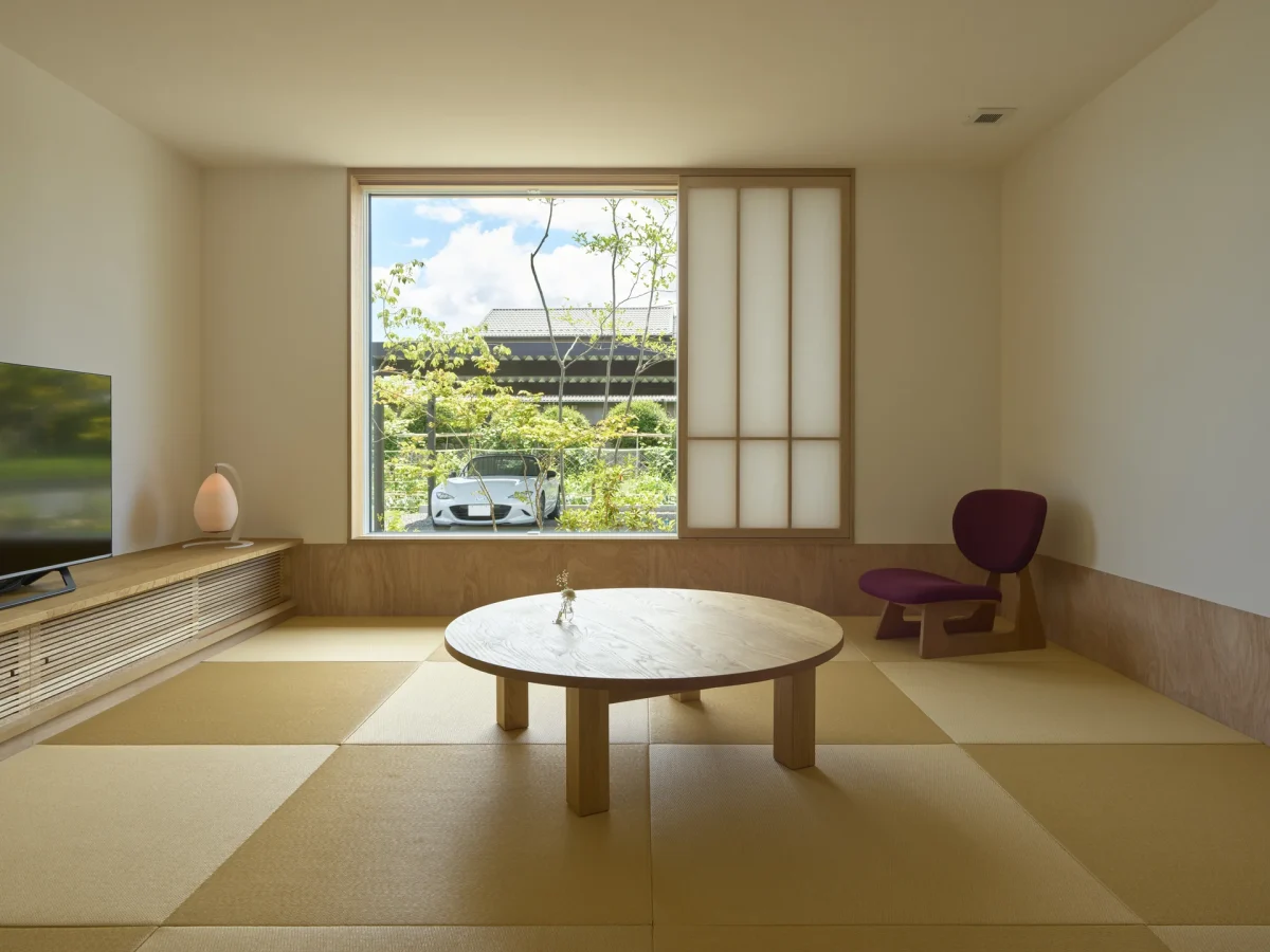 庭を望む窓辺に丸いテーブルを置いた畳の部屋