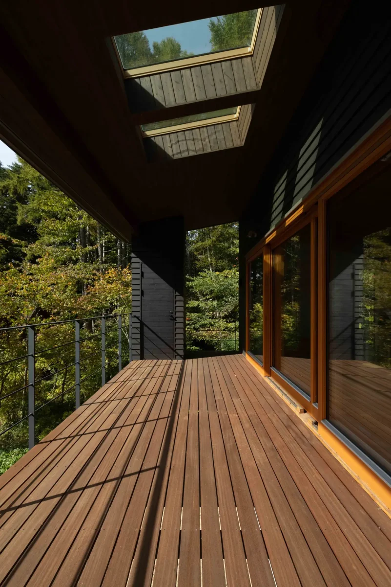 木々を眺める、建物に沿って延びるウッドデッキ